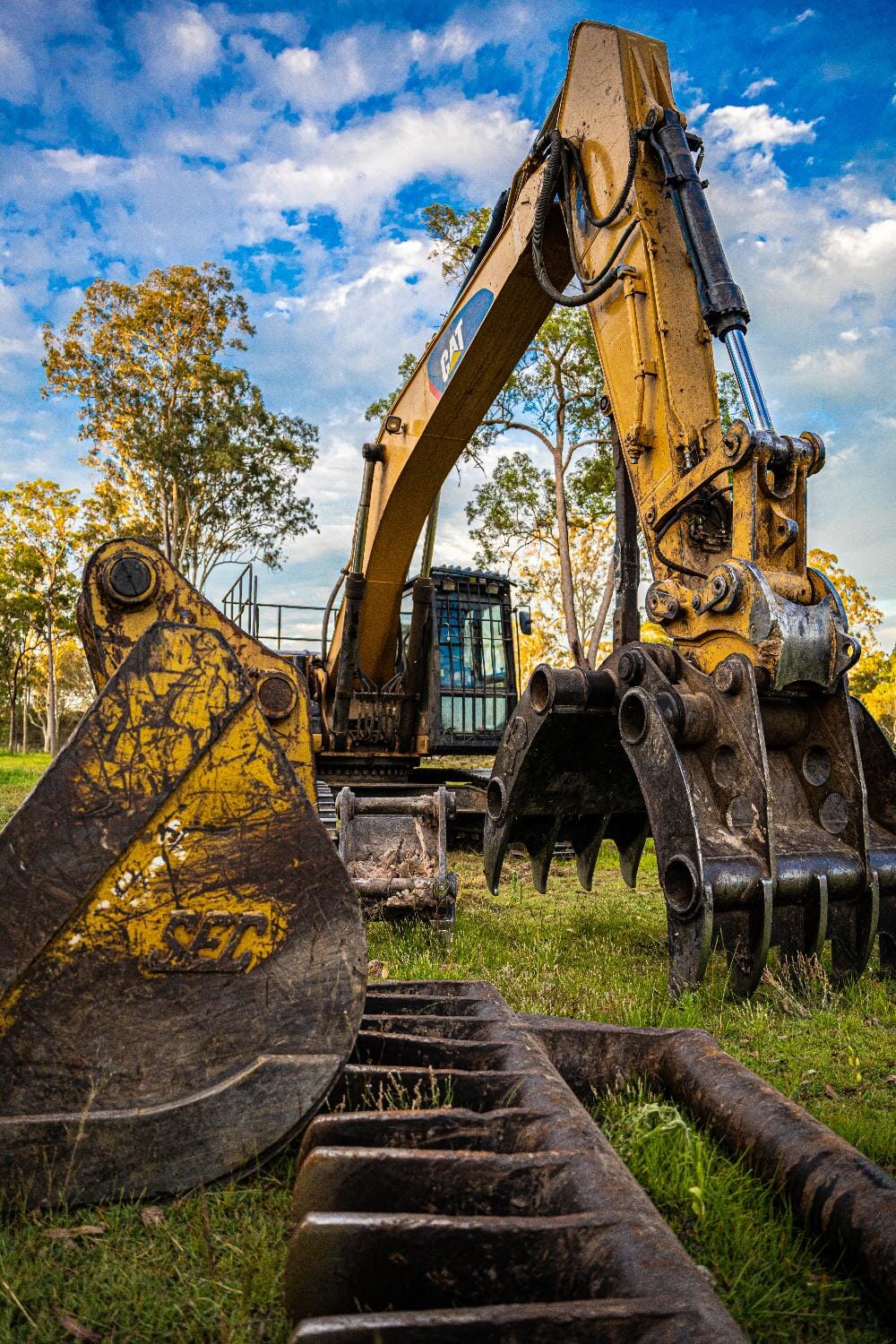 CAT excavator and grapple attachment on site at dusk